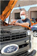 Single worker, performing maintenance on ford truck.