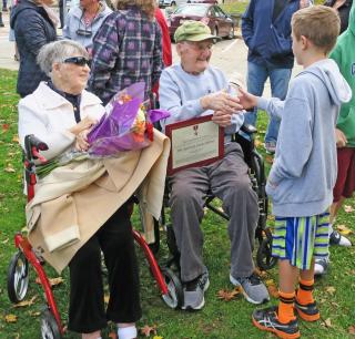 Marjorie and Bernie greeting a boy