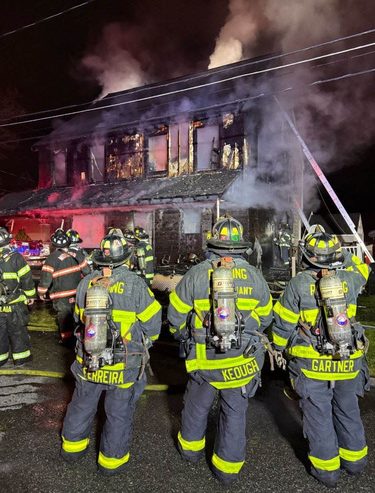 Three firefighters in front a building that had burnt